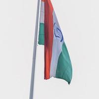 India flag flying high at Connaught Place with pride in blue sky, India flag fluttering, Indian Flag on Independence Day and Republic Day of India, tilt up shot, Waving Indian flag, Har Ghar Tiranga photo