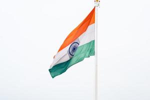 India flag flying high at Connaught Place with pride in blue sky, India flag fluttering, Indian Flag on Independence Day and Republic Day of India, tilt up shot, Waving Indian flag, Har Ghar Tiranga photo