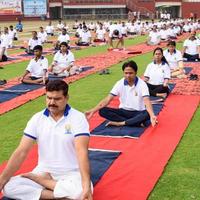 New Delhi, India, June 21 2022 - Group Yoga exercise session for people at Yamuna Sports Complex in Delhi on International Yoga Day, Big group of adults attending yoga class in cricket stadium photo