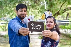 pareja india posando para una sesión de fotos de maternidad. la pareja está posando en un césped con hierba verde y la mujer está faluntando su panza en el jardín lodhi en nueva delhi, india