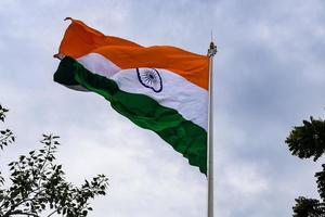 India flag flying high at Connaught Place with pride in blue sky, India flag fluttering, Indian Flag on Independence Day and Republic Day of India, tilt up shot, Waving Indian flag, Har Ghar Tiranga photo