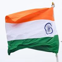 India flag flying high at Connaught Place with pride in blue sky, India flag fluttering, Indian Flag on Independence Day and Republic Day of India, tilt up shot, Waving Indian flag, Har Ghar Tiranga photo