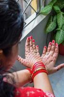 hermosa mujer vestida como tradición india con diseño de henna mehndi en ambas manos para celebrar el gran festival de karwa chauth, celebraciones de karwa chauth de una mujer india para su marido foto