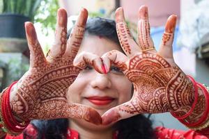 hermosa mujer vestida como tradición india con diseño de henna mehndi en ambas manos para celebrar el gran festival de karwa chauth, celebraciones de karwa chauth de una mujer india para su marido foto