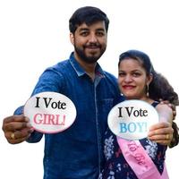 Indian couple posing for maternity baby shoot with white plain background. The couple is posing in a lawn with green grass and the woman is falunting her baby bump in Lodhi Garden in New Delhi, India photo