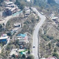 Aerial top view of traffic vehicles driving at mountains roads at Nainital, Uttarakhand, India, View from the top side of mountain for movement of traffic vehicles photo