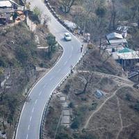 Aerial top view of traffic vehicles driving at mountains roads at Nainital, Uttarakhand, India, View from the top side of mountain for movement of traffic vehicles photo