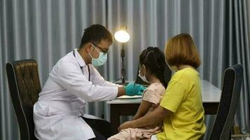 pediatra masculino realiza exame de estetoscópio menina bonitinha paciente visita médico com a mãe, pediatra ouve batimentos cardíacos infantis faz check-up pediátrico no hospital, conceito de assistência médica infantil video