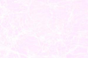 Defocus blurred transparent orange colored clear calm water surface texture with splashes and bubbles. Trendy abstract nature background. Water waves in sunlight with caustics. Pink water shinning photo