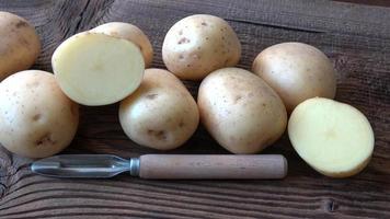 pommes de terre sur la planche de bois. pomme de terre fraîche sur fond rustique video