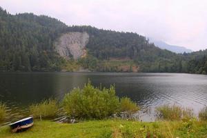 viaje a sankt-wolfgang, austria. la vista sobre el lago de las montañas con el barco azul-blanco en primer plano. foto