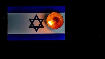 Israeli flag and candles burning above it, Holocaust memory day photo