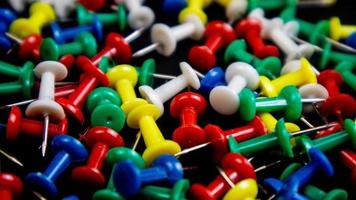 multicolored thumbtacks on a black background photo