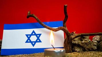 Israeli flag and candles burning in front of it, Holocaust memory day photo