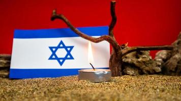 Israeli flag and candles burning in front of it, Holocaust memory day photo