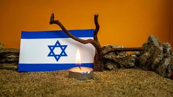 Israeli flag and candles burning in front of it, Holocaust memory day photo