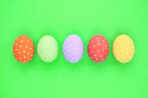 Easter coloured eggs with polka dot on green background. Flatlay postcard creative concept. Isolated decorated card, poster, banner, web, magazine. Minimal idea with copy space, close up spring photo