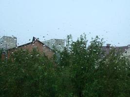 días de lluvia gotas de lluvia en la superficie de la ventana foto