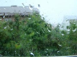 días de lluvia gotas de lluvia en la superficie de la ventana foto