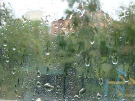 días de lluvia gotas de lluvia en la superficie de la ventana foto