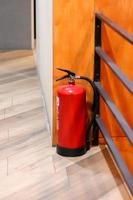 el extintor de incendios rojo está listo para usar en caso de una emergencia de incendio interior. foto