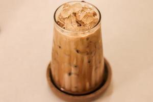 High-angle view of glass of an iced coffee with creamy milk. Cold brew coffee drink with ice. photo