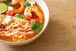 instant noodles ramen in spicy soup with shrimps - Tom Yum Kung photo