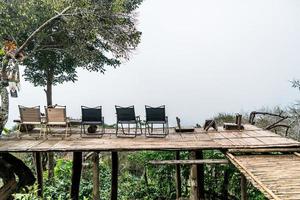 chair on balcony with mountain hill and foggy background photo