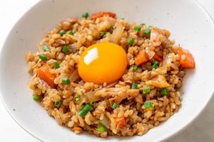 arroz frito con salmón y huevo encurtido encima foto