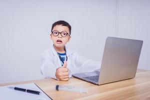 niño asiático doctor usando una computadora portátil foto