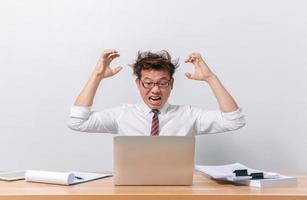 hombre de negocios asiático sentado y trabajando y estresado foto