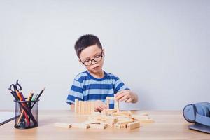 niño asiático jugando con un rompecabezas de madera foto