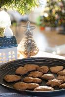 Festive Christmas decor in table, homemade cakes for breakfast, bakery cookies. Cozy home, christmas tree with fairy lights garlands. New Year, christmas mood photo