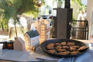 decoración navideña festiva en la mesa, pasteles caseros para el desayuno, galletas de panadería. hogar acogedor, árbol de navidad con guirnaldas de luces de hadas. año nuevo, estado de ánimo navideño foto