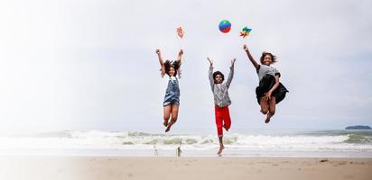 tamaño de la pancarta. grupo de niños afroamericanos felices saltando en una playa tropical foto