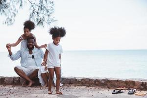 African American family, Father, Two daughters enjoying together at the seaside. photo