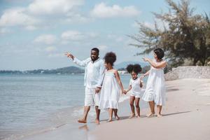 familia de vacaciones de verano. familia afroamericana jugando juntos en la playa de vacaciones foto