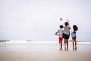 momento feliz de la parte trasera de los niños afroamericanos en una playa tropical. concepto étnicamente diverso foto