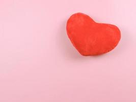 flat lay of red heart pillow on pink background. photo