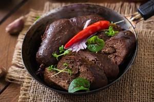 Homemade blood sausage with offal on the old wooden background in rustic style photo