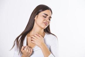 Young woman scratching her neck due to itching on a gray background. Female has an itching neck. The concept of allergy symptoms and healthcare photo