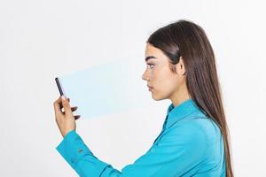 identificación biométrica. joven hermosa mujer escaneando la cara con el sistema de reconocimiento facial en el teléfono inteligente. foto