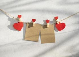 Red hearts on a rope with clothespins. photo
