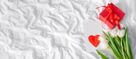 Tulips flowers, red gift box and empty card with heart for text. Mockup. Concept of womens day, mothers day photo