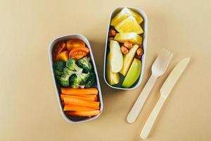 Lunch boxes with vegetables and fruits. Wooden cutlery, zero waste, eco friendly concept. Top view photo