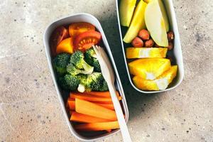 Lunch boxes with vegetables and fruits. Delicious balanced food concept. Healthy living concept. photo