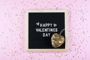 Happy Valentines Day Card. Letters board with text and gold heart. Flat lay, top view photo