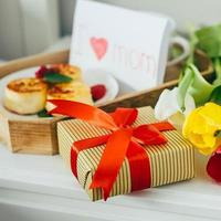 primer plano de caja de regalo y tulipanes para el día de la madre. brunch o desayuno festivo. concepto de buenos dias foto