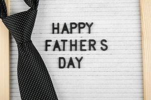 tablero de cartas con felicitaciones letras feliz día del padre y corbata de hombre accesorio.