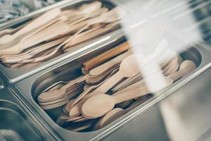 Many wooden spoons and forks in metal container. Concept of zero waste, eco friendly, organic items photo